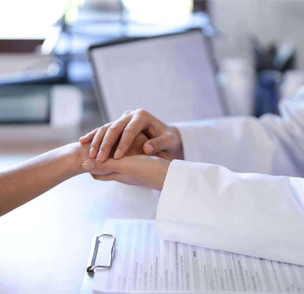 Psychiatrist holding a patient’s hands during a consultation session, representing compassionate care from the best psychiatrist in Lahore and trusted support from a top psychiatrist in Lahore.